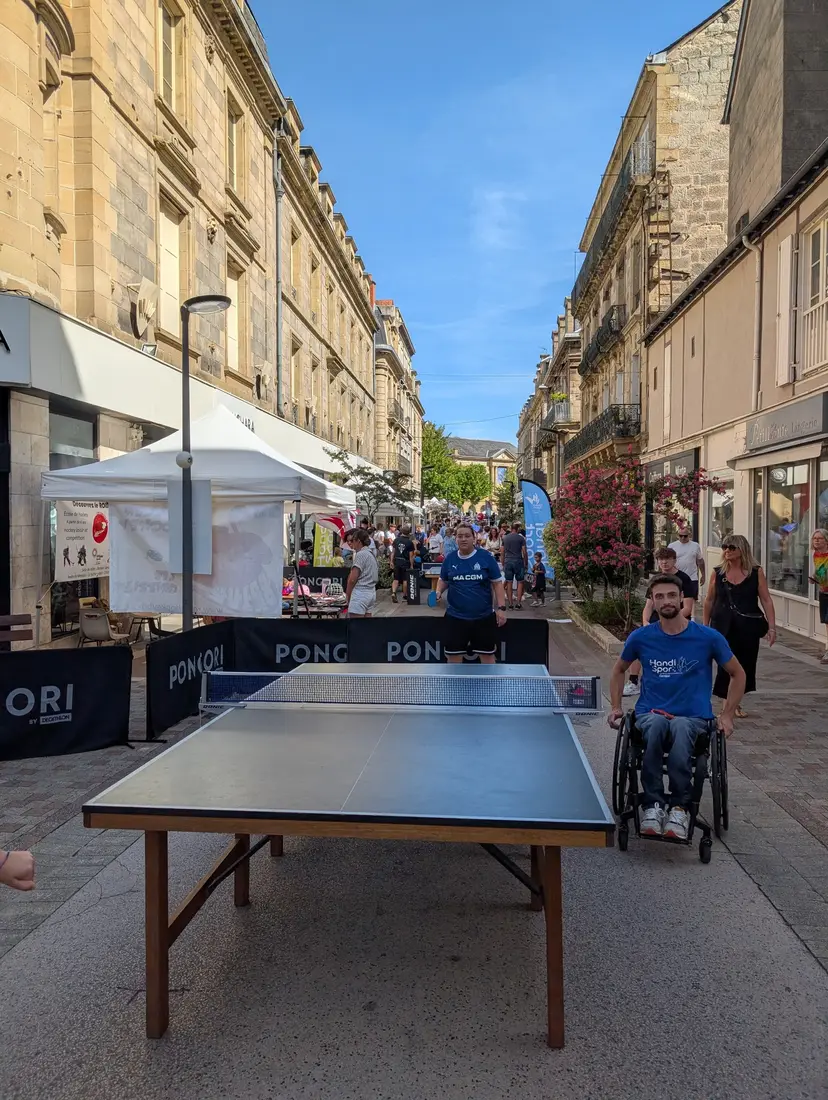 Un joueur en fauteuil du pôle handisport à la table, rue de l'Hôtel de Ville